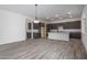 Spacious kitchen featuring sleek cabinetry, a central island, and modern appliances, with an adjacent living space at 18564 W Cathedral Rock Dr, Goodyear, AZ 85338