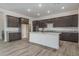 Modern kitchen featuring dark cabinets, stainless appliances, a large island, and an open layout at 18564 W Cathedral Rock Dr, Goodyear, AZ 85338