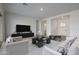 Well-lit living room with modern decor, tile flooring, and a view of the front entrance and hall at 18564 W Cathedral Rock Dr, Goodyear, AZ 85338