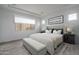 Staged main bedroom featuring wood-style tile flooring, neutral decor, and ample natural light at 18564 W Cathedral Rock Dr, Goodyear, AZ 85338