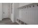 Mud room area showcases a built-in bench, cubbies, coat hooks, and light gray tile flooring at 18564 W Cathedral Rock Dr, Goodyear, AZ 85338