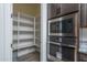 Walk-in pantry with abundant shelving next to stainless steel microwave and oven at 18564 W Cathedral Rock Dr, Goodyear, AZ 85338