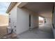 Covered patio featuring bare cement and partial view of the unlandscaped backyard and house exterior at 18564 W Cathedral Rock Dr, Goodyear, AZ 85338