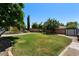 Expansive backyard featuring lush green grass, mature trees, and a unique raised planter bed at 1870 E Oakland St, Gilbert, AZ 85295