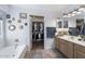 Well-lit bathroom featuring double sinks, a bathtub, and access to a spacious walk-in closet at 1870 E Oakland St, Gilbert, AZ 85295