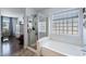 Bright bathroom with a glass enclosed shower, a soaking tub, and a window allowing natural light in at 1870 E Oakland St, Gilbert, AZ 85295