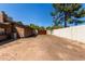 Large, empty backyard space with a view of the fence and a side view of a building at 2043 E Quartz St, Mesa, AZ 85213