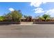 Charming single-story home featuring a brick facade, gated entrance, and mature trees, offering both privacy and curb appeal at 2043 E Quartz St, Mesa, AZ 85213