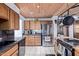 Functional kitchen boasts stainless steel refrigerator, wood cabinets, and tile flooring at 2043 E Quartz St, Mesa, AZ 85213