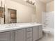 A bathroom features double sinks, plenty of storage, and a shower with a tub at 22322 N 77Th St, Scottsdale, AZ 85255