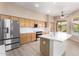 Bright kitchen features stainless steel appliances, ample cabinets and center island with sink at 22322 N 77Th St, Scottsdale, AZ 85255