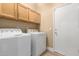 A laundry room featuring washer and dryer, overhead cabinets, and access door to the exterior at 22322 N 77Th St, Scottsdale, AZ 85255