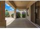 A covered patio extends outdoor living, complemented by vibrant bushes and a sliding glass door at 22322 N 77Th St, Scottsdale, AZ 85255