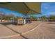 A playground features a variety of equipment under a shaded canopy, set in a sand-filled play area at 22322 N 77Th St, Scottsdale, AZ 85255