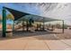 A shaded playground is equipped with slides and climbing structures, nestled in a desert landscape at 22322 N 77Th St, Scottsdale, AZ 85255