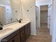 Bathroom featuring double vanity with dark cabinets, light countertop, black fixtures, and walk-in shower at 22359 W Monona Ln, Surprise, AZ 85387