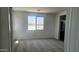 Bright, carpeted bedroom featuring a large window with mountain views, neutral walls, and ample natural light at 22359 W Monona Ln, Surprise, AZ 85387