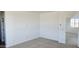 Clean carpeted bedroom with white walls, ample natural light, and a view to another room at 22359 W Monona Ln, Surprise, AZ 85387