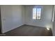 Cozy carpeted bedroom with a window providing natural light, and white walls at 22359 W Monona Ln, Surprise, AZ 85387