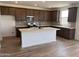 Modern kitchen features an island, stainless steel appliances, dark cabinets, and light countertops at 22359 W Monona Ln, Surprise, AZ 85387