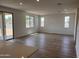 Spacious living room features wood-look tile floors, neutral paint, and bright natural light at 22359 W Monona Ln, Surprise, AZ 85387