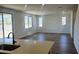 Bright living room with tile floors, large windows, and direct access to an adjacent kitchen space at 22359 W Monona Ln, Surprise, AZ 85387