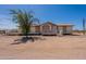Tan single story home featuring a front porch and a large yard with sparse vegetation at 22819 E Ray Rd, Mesa, AZ 85212