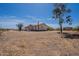 Tan single story home with sparse vegetation and a dirt lot in a rural area at 22819 E Ray Rd, Mesa, AZ 85212