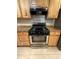 Stainless steel and black gas range and oven with wooden cabinets and granite countertops at 2401 W Weldon Ave, Phoenix, AZ 85015