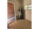 Shows a utility room with tile floors, a window, and a hot water heater unit at 2401 W Weldon Ave, Phoenix, AZ 85015