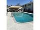 Community pool with shaded seating area surrounded by wrought iron fence at 2569 W Berridge Ln # D-115, Phoenix, AZ 85017