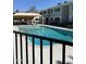 Community pool surrounded by wrought iron fencing, tables and chairs at 2569 W Berridge Ln # D-115, Phoenix, AZ 85017