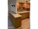 Charming kitchen featuring wood cabinets, tile backsplash, a dual basin sink, and wood-look tile floors at 2569 W Berridge Ln # D-115, Phoenix, AZ 85017