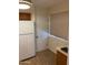 Kitchen area shows a white refrigerator, door to the pantry, and blinds on the window at 2569 W Berridge Ln # D-115, Phoenix, AZ 85017