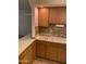 Inviting kitchen boasting wood cabinets, laminate countertops, a dual basin sink, and tiled backsplash at 2569 W Berridge Ln # D-115, Phoenix, AZ 85017