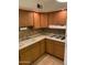 Bright kitchen showcasing wood cabinets, dual basin sink, electric range, and tiled backsplash at 2569 W Berridge Ln # D-115, Phoenix, AZ 85017