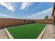 Spacious backyard area with artificial grass, rock landscaping, and secure wall at 28072 N Quartz Dr, San Tan Valley, AZ 85143