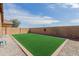 Large backyard featuring artificial grass, gravel landscaping, and block wall fencing for privacy at 28072 N Quartz Dr, San Tan Valley, AZ 85143
