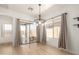 Bright dining area with wood floors, natural light, stylish chandelier, and sliding door access to the backyard at 28072 N Quartz Dr, San Tan Valley, AZ 85143