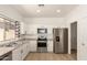 Bright kitchen features white cabinets, stainless appliances, and light wood flooring at 28072 N Quartz Dr, San Tan Valley, AZ 85143
