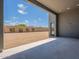 Covered patio leading to a spacious backyard with gravel, greenery, and privacy wall at 28421 N 59Th Way, Cave Creek, AZ 85331