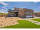Beautiful modern home with a stone facade, desert landscaping, and a well-manicured artificial lawn at 28421 N 59Th Way, Cave Creek, AZ 85331