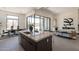 Modern kitchen with a marble countertop island, stylish chairs, and access to the outdoor patio through large glass doors at 28421 N 59Th Way, Cave Creek, AZ 85331