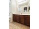 This bathroom features dark wood cabinets, tile flooring, and a large mirror over the vanity at 2947 N Evergreen St, Buckeye, AZ 85396