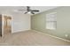Well lit bedroom with carpet floors, neutral paint, ceiling fan, and large window at 2947 N Evergreen St, Buckeye, AZ 85396
