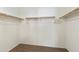 Walk-in closet featuring carpet floors, white paint, and wooden racks at 2947 N Evergreen St, Buckeye, AZ 85396