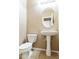 This half-bathroom features a pedestal sink, a toilet, and neutral-colored walls at 2947 N Evergreen St, Buckeye, AZ 85396