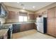 Well-equipped kitchen with stainless steel appliances, dark cabinets, and a tiled floor at 2947 N Evergreen St, Buckeye, AZ 85396