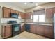 The kitchen has dark wood cabinets, black appliances, and tile flooring at 2947 N Evergreen St, Buckeye, AZ 85396