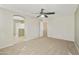 Large primary bedroom with a ceiling fan, neutral paint, carpet and an arched entry to bathroom at 2947 N Evergreen St, Buckeye, AZ 85396